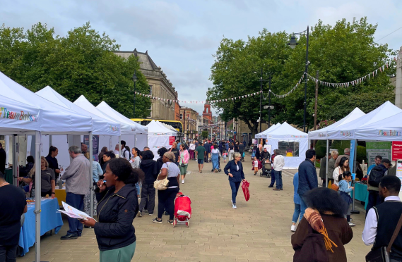 Image of past event at Victoria Square with people and gazebos